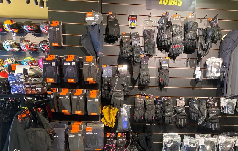 Parede com luvas, camisetas e jaquetas para motociclistas